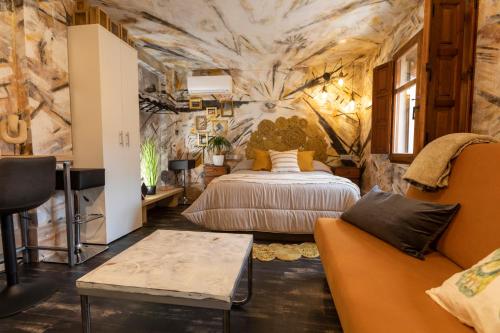 - une chambre avec un lit et un canapé dans l'établissement Domus Lapidis - La Galeria, à Bogarra