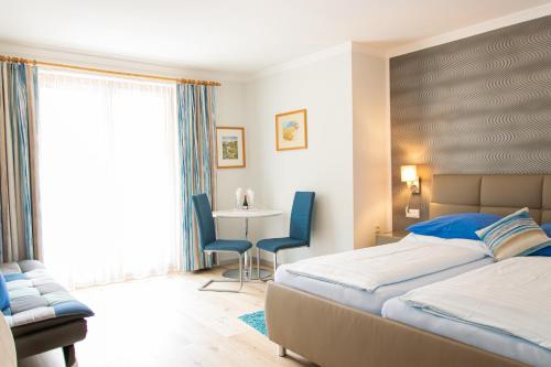 1 dormitorio con 1 cama, mesa y sillas en Hotel Burgstallerhof, en Feld am See