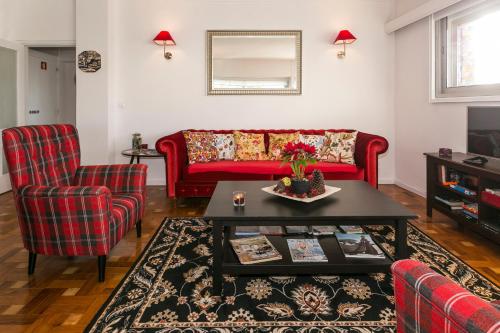 a living room with a red couch and two chairs at Apartamento Vintage 1 in Porto