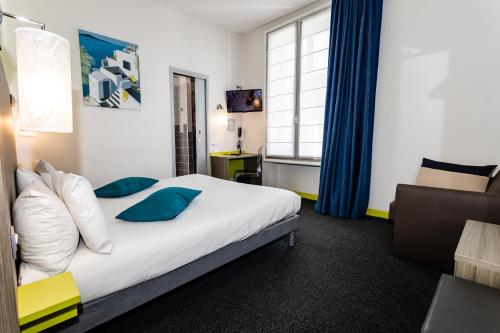 a hotel room with a bed and a chair at Hôtel de Champagne in Angers