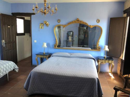 a blue bedroom with a bed and a mirror at El Pósito in Hita