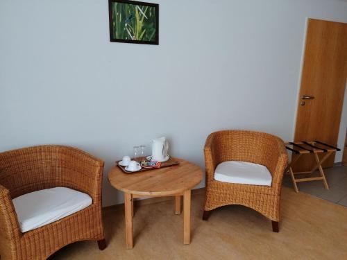two chairs and a wooden table with a table and two chairs at Doppelzimmer Gästehaus Mühlenstein in Bad Sülze