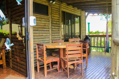 a wooden table and chairs on a wooden deck at Bungalows Ballena in Uvita