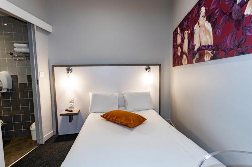 a bedroom with a large white bed and a shower at Hôtel de Champagne in Angers