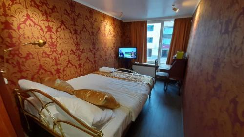 a hotel room with a bed and a television at Bosdam Budget Rooms in Beveren