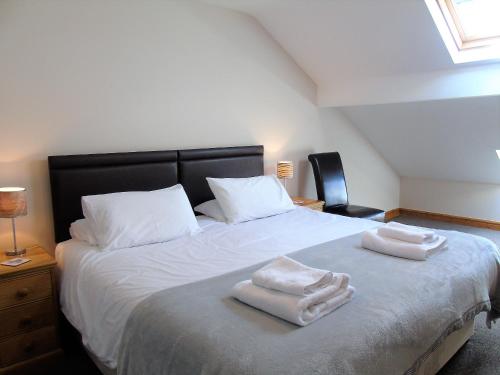 比爾斯韋爾斯的住宿－Gwilym's Stable，一间卧室配有一张床,上面有两条毛巾