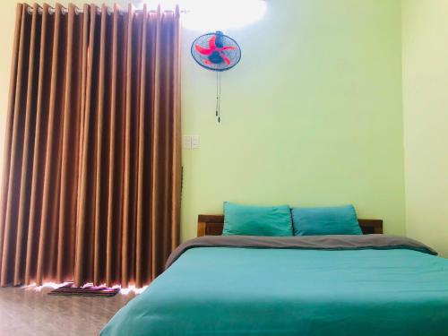 a bedroom with a bed and a window with curtains at Vy Ly Motel in Phú Quí (2)