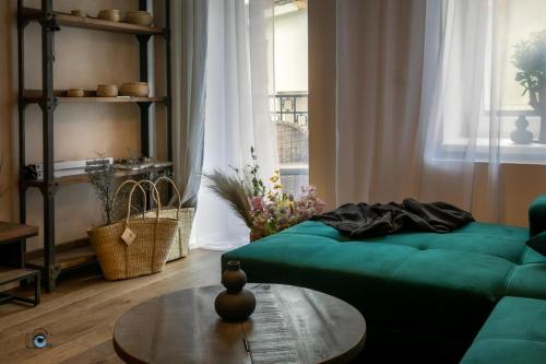 a living room with a green couch and a table at Sting Old Town Ostrava in Ostrava