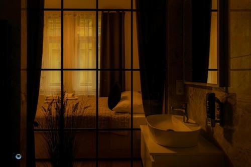 a bathroom with a sink and a mirror and a bed at Sting Old Town Ostrava in Ostrava
