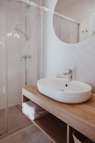 a white bathroom with a sink and a shower at Forest House Pobierowo in Pobierowo