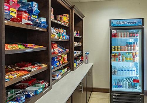 a grocery store aisle with a refrigerator filled with food at Holiday Inn Express & Suites Houston South - Near Pearland by IHG in Houston