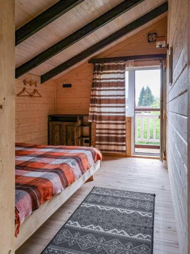 a bedroom with a bed and a large window at Котедж Скеля in Vorokhta