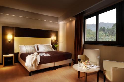 a bedroom with a bed and a table and a window at San Severino Park Hotel & SPA, BW Signature Collection in Mercato San Severino