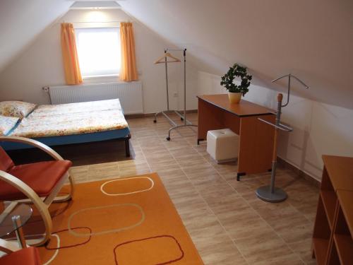 a bedroom with a bed and a table and a desk at Penzion Cabák in Vrchlabí