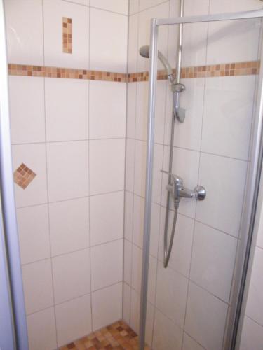 a shower in a bathroom with white tiles at Sonniges Ferienhaus Fischer-Huus vor Usedom & direkt am Haff und Wasserzugang in Mönkebude