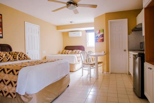 a hotel room with two beds and a table at Hotel Santa Fe Los Cabos by Villa Group in Cabo San Lucas