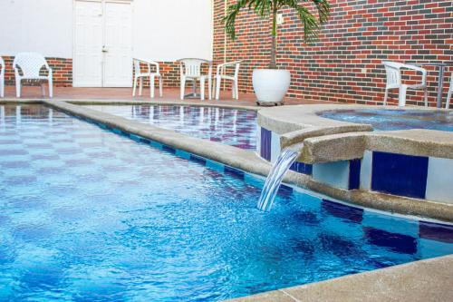 a swimming pool with a waterfall in the middle at Hotel Fenix in Cúcuta