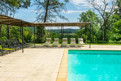 une piscine avec des chaises et un gazebo dans l'établissement Le Mas Toupian, à Goudargues
