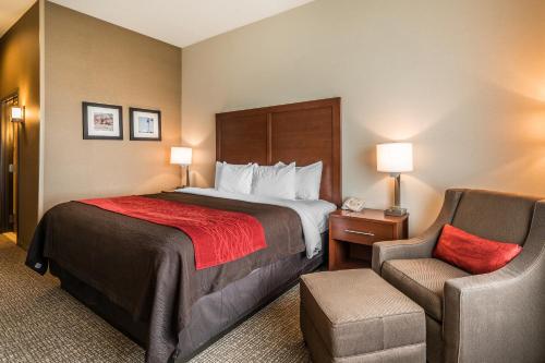 a hotel room with a bed and a chair at Comfort Inn & Suites in Hermiston
