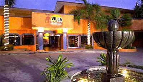 a building with a fountain in front of a store at Hotel Villa Mexicana in Zihuatanejo