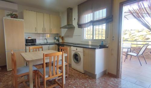 a kitchen with a table and chairs and a table and a kitchen with a laundry at Villa del Carmen in Almayate Alto