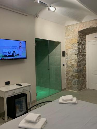 a bedroom with a glass shower and a bed with two towels at Spa & Wellness by Des Anglais " Accesso SPA compreso" in Sanremo