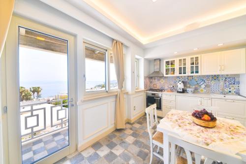 a kitchen with a table and a view of the ocean at Belgodere di Mezzavia Apartments in Ischia