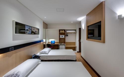 Habitación de hotel con 2 camas y TV en Denali Hotel, en Anápolis