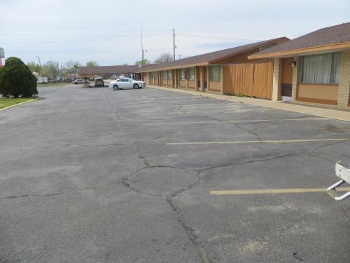 a parking lot with a car parked in front of a building at Traveler's Lodge in Salina