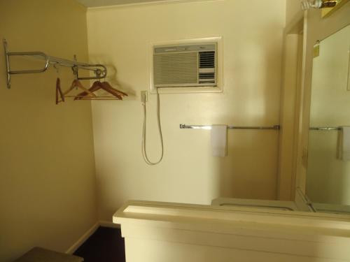 uma casa de banho com um chuveiro, uma ventoinha e uma janela. em Traveler's Lodge em Salina