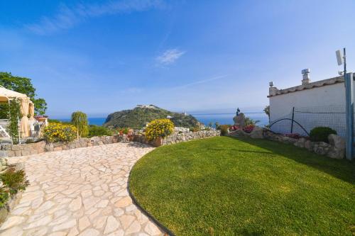 a garden with a stone walkway and a house at Belgodere di Mezzavia Apartments in Ischia