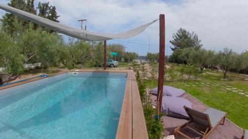 basen z białym parasolem i krzesłami w obiekcie Agios Mamas Resort w mieście Nea Potidaea
