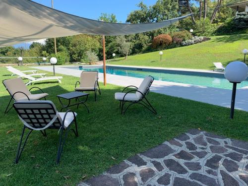 a group of chairs and a table next to a pool at Villa Barbara in Salò