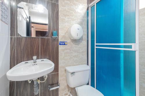 a bathroom with a sink and a toilet and a mirror at Ayenda Castillo Real 1521 in Bucaramanga