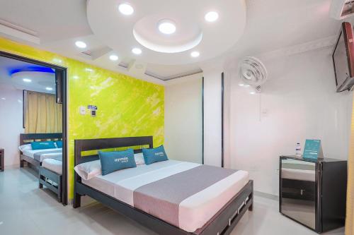 a bedroom with two beds and a green wall at Ayenda Castillo Real 1521 in Bucaramanga