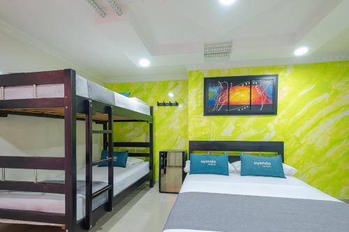 a bedroom with two bunk beds and a yellow wall at Ayenda Castillo Real 1521 in Bucaramanga
