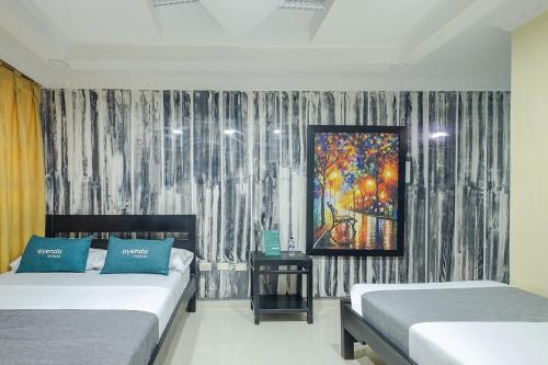 a bedroom with two beds and a painting on the wall at Ayenda Castillo Real 1521 in Bucaramanga