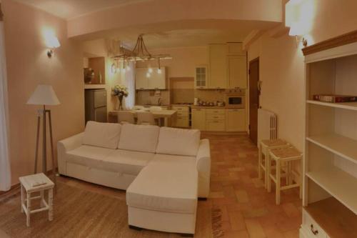 Il comprend un salon avec un canapé blanc et une cuisine. dans l'établissement Casa Vacanze San Francesco, à Assise