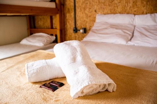 a hotel room with two towels on a bed at Esquina 8 Suítes Confort & Hostel in Florianópolis