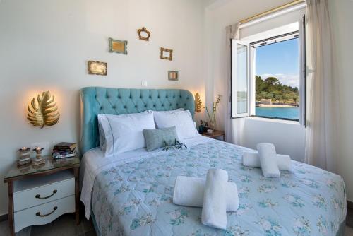 a bedroom with a blue bed and a window at Sea Front Suite "SEA TALES" in Gaios