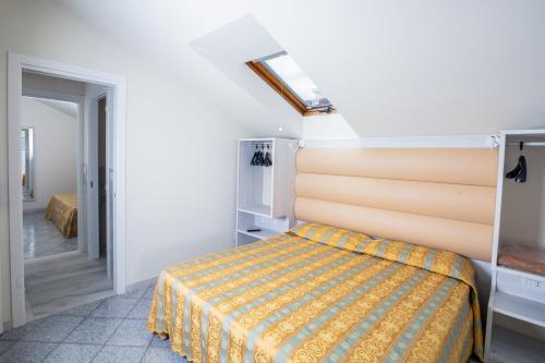 a bedroom with a bed with a yellow bedspread at Hotel Rosalba - Valentini Family Village in Bellaria-Igea Marina