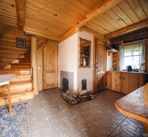 a large room with a fireplace in a log cabin at Gravas dzirnavas in Dārznieki