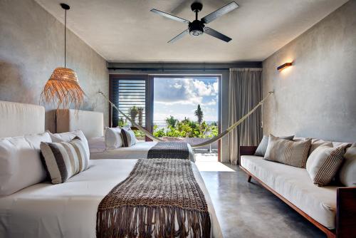 a living room with white couches and a large window at Beachfront Villa in Tankah Bay in Tulum