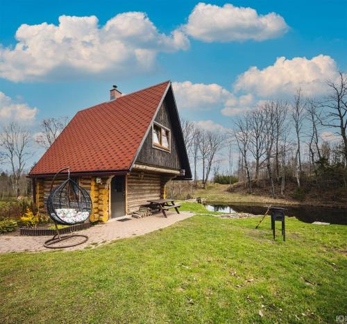 une petite maison avec une aire de jeux dans un champ dans l'établissement Gravas dzirnavas, 