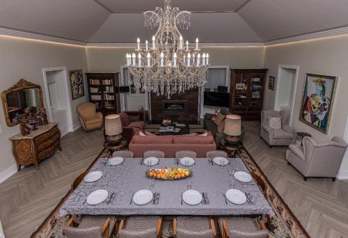 a living room with a table and a chandelier at Casa das Margaridas in Vale de Lobo
