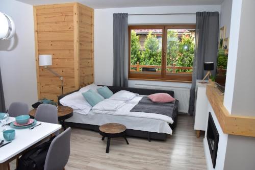 a small bedroom with a bed and a window at Apartament Erica in Zakopane