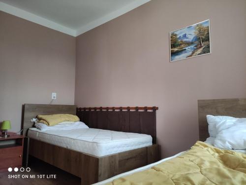 a bedroom with two beds and a picture on the wall at Rákóczi Vendégház in Poroszló