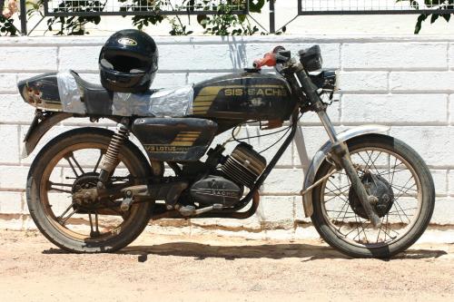 a motorcycle parked in front of a brick wall at B&B Candelária in Loulé