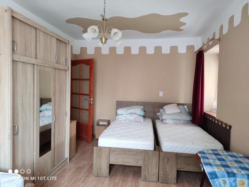 a bedroom with two beds and a mirror at Rákóczi Vendégház in Poroszló