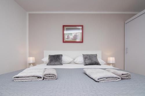 um quarto branco com uma cama grande e 2 almofadas em Apartman Mara em Krk